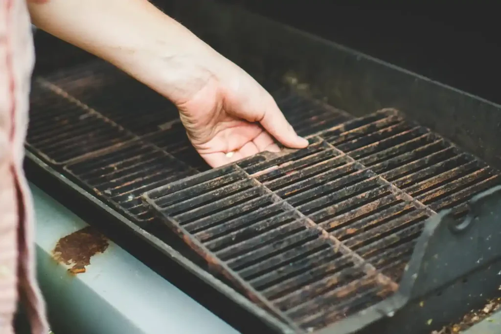 Person cleaning grill grates