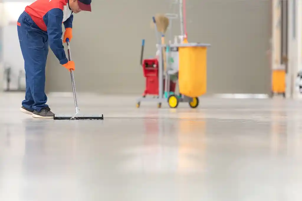 Professional cleaner cleaning garage floor
