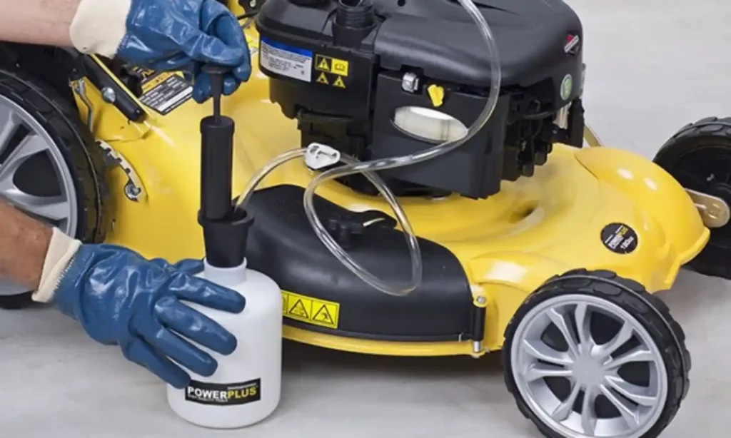 A person siphoning gas using a water hose by creating suction, with one end of the hose in a gas tank and the other end positioned lower to allow gravity to draw the fuel out