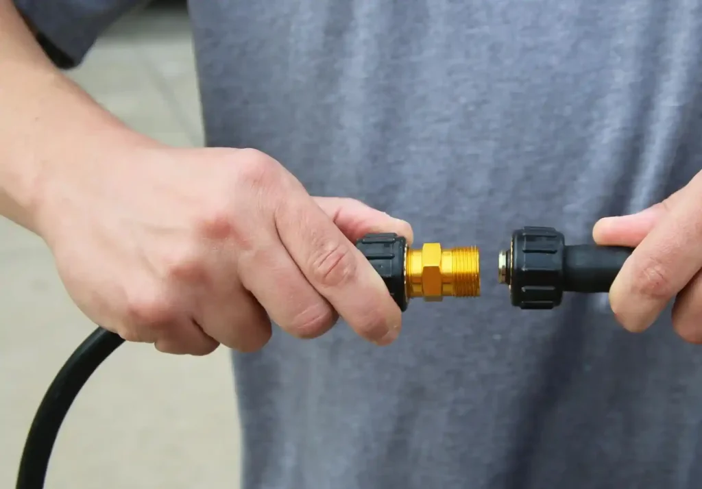 A man trying to attach water hose power wash attachment